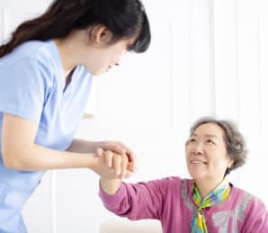 female caregiver holding the hands of the senior woman