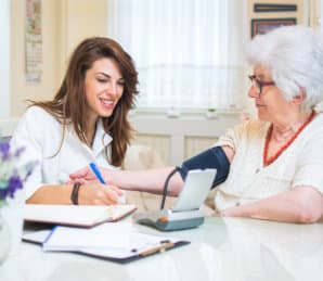 female nurse checking blood pressure of the senior woman