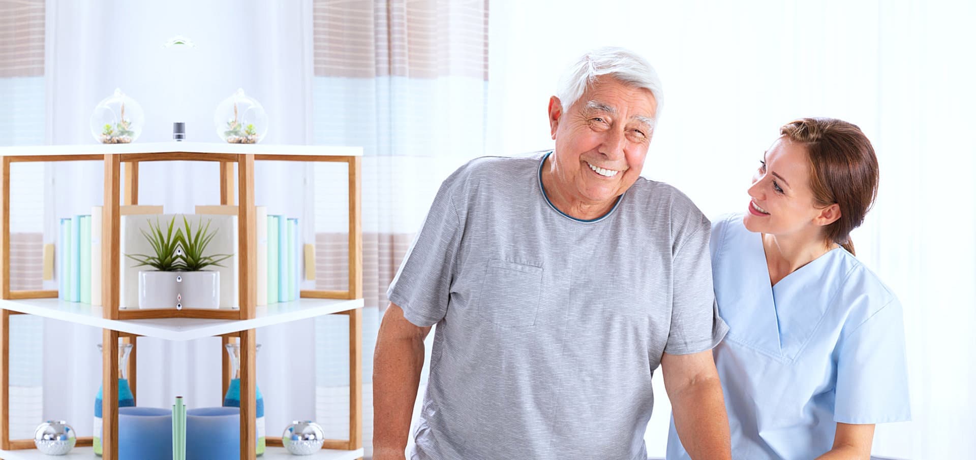 senior man smiling while female caregiver looking at him