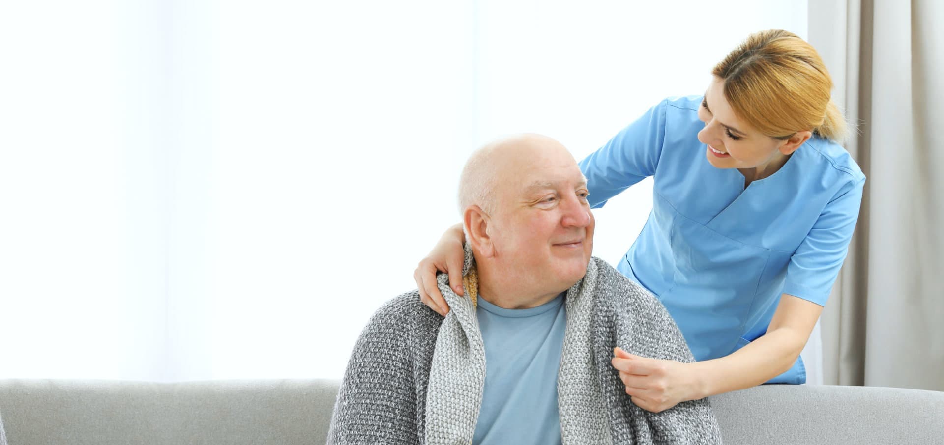 senior man and female caregiver looking at each other