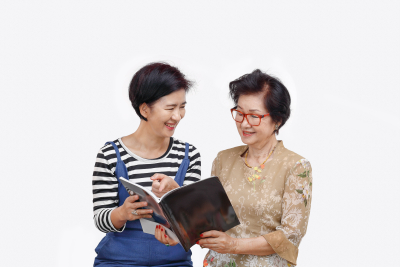 caregiver and  senior woman reading a book
